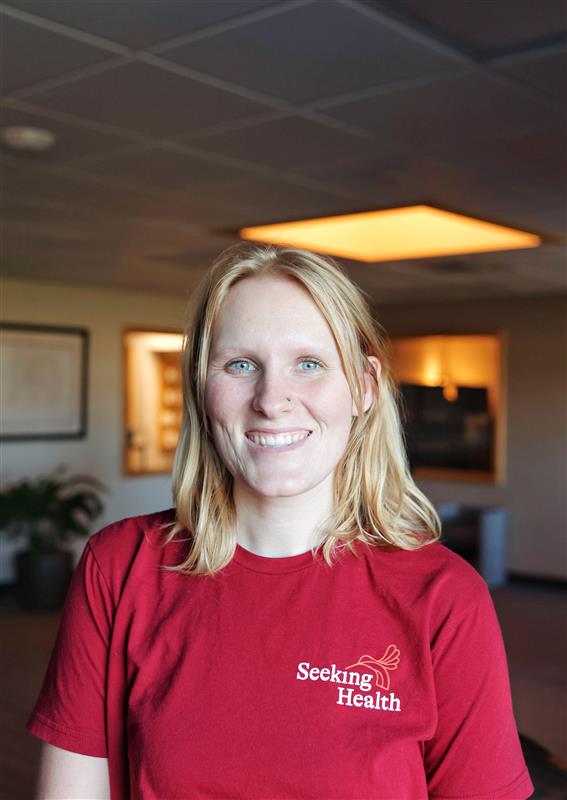 Person wearing a red 'Seeking Health' shirt in an indoor setting