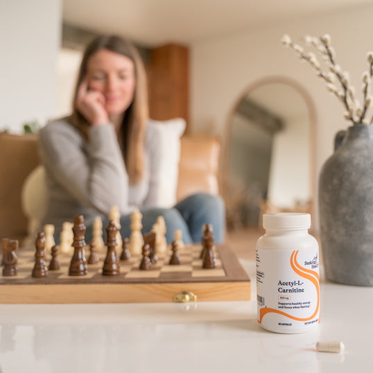 image of woman sitting down to a chess game