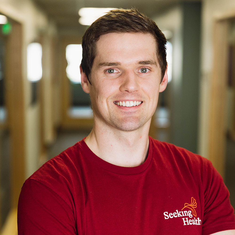 Man wearing a red 'Seeking Health' shirt in a hallway