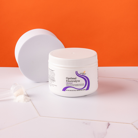 White container labeled 'Optimal Electrolyte' on a pink surface with an orange background