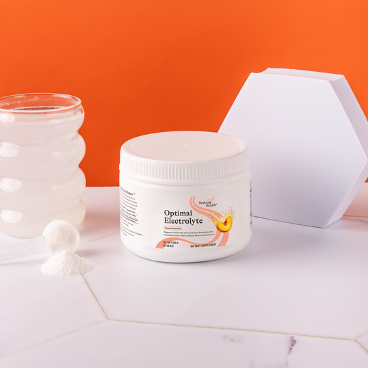 Container of 'Optimal Electrolyte' on a marble surface with an orange background