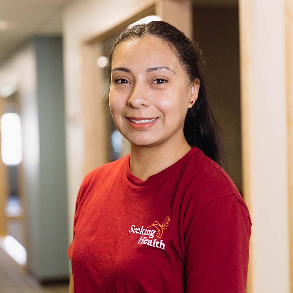 Person wearing a red 'Seeking Health' shirt in an indoor setting