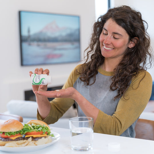 Woman uses Saccharomyces Boulardii supplement to support healthy digestion.